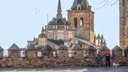 Dos personas contemplan la iglesia de Santa María de la Encarnación desde la fortaleza templaria de Jerez de los Caballeros, en la provincia de Badajoz.