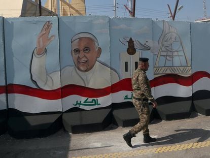 Un soldado iraquí pasa delante de un muro de hormigón decorado con la efigie del Papa Francisco, ante su próxima visita a Irak.