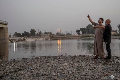 Vecinos de las proximidades del río Éufrates, en Raqa, pasan un rato de descanso junto a un puente derrumbado, destruido durante la batalla para recuperar la ciudad de las manos del grupo extremista Estado Islámico. En su día, Raqa fue la capital del EI en Siria.