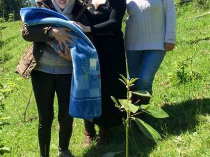 Yoana Aron junto con dos miembros de la comunidad huilliche tras la celebraci&oacute;n en la que se plant&oacute; la placenta junto con un peque&ntilde;o &aacute;rbol. 