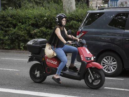 Una usuaria de una moto eléctrica compartida, en Barcelona.