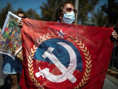 Una mujer muestra una bandera del Partido Comunista de Chile.