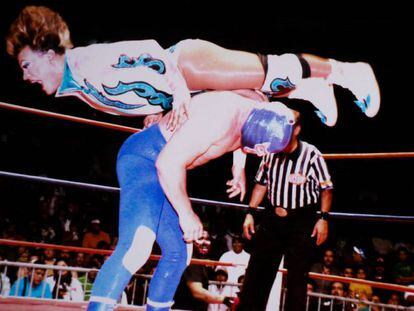 Cassandro salta sobre un rival en un combate de lucha libre mexicana.