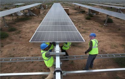 Dos trabajadores ajustan una placa en la planta fotovoltaica de Iberdrola en San Luis de Potos&iacute; (M&eacute;xico).