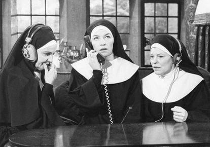 Frame from the film 'Bad habits' (1977).  Sister Alexandra (played by Glenda Jackson) talks on the phone while two other nuns listen in on the conversation.