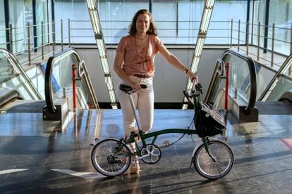 Isabel Ramis posa con su bici plegable en la entrada de una estación de metro de Madrid. 