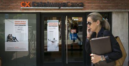 Una mujer pasa por delante de una oficina de Catalunya Caixa de Barcelona.