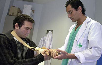 El doctor Pedro Cavadas (derecha) mientras observaba ayer el brazo izquierdo de Israel Sarrió.