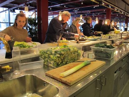 Varios clientes se sirven comida en el restaurante K-märkt.
