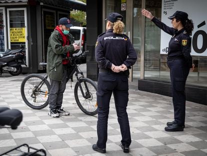 Agentes de la Policia Nacional informan a un usuario en bicicleta en el centro de Granada.