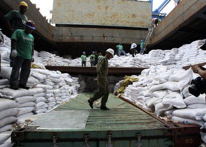 Un grupo de trabajadores desvela varios contenedores ocultos entre sacos de azúcar y que presumiblemente contienen material bélico, dentro del barco norcoreano Chong Chon Gang.