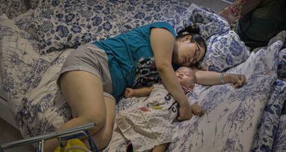 La siesta no entiende de edades. Una madre y su hijo descansan en una cama de exposición de una tienda de IKEA en China