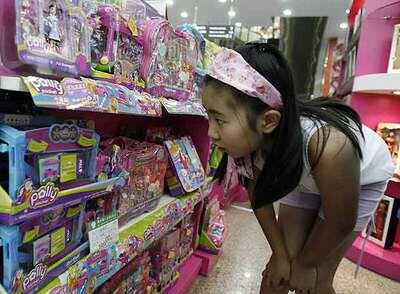 Una niña china, ante un estante con juguetes de Polly Pocket en una tienda en Pekín.
