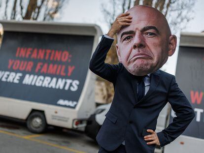 Un hombre con un retrato de Infantino, presidente de la FIFA, protesta en Suiza.
