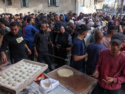 Un grupo de palestinos espera para adquirir pan en la ciudad de Khan Yunis, en el sur de la franja de Gaza, este martes.