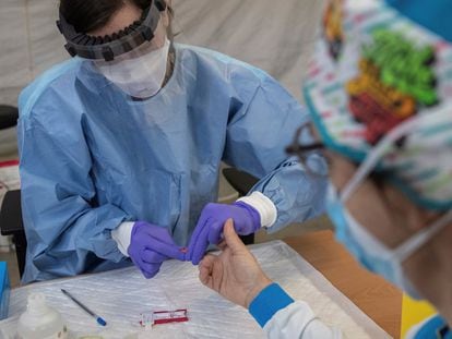 Un sanitario realizan el test rápido de diagnóstico a un trabajado del Summa durante una guardia de 24 hora en el centro de salud Las Águilas, en Madrid.