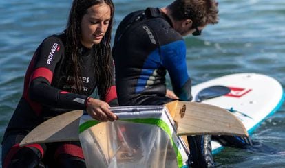Voluntaris reullen plàstics a la platja de Barcelona per al projecte Surfing for Science.