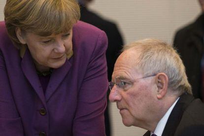 Merkel habla con el ministro Sch&auml;uble, en la reuni&oacute;n de la CDU.