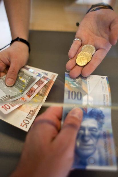 Fotografía de archivo del 8 de junio de 2011 que muestra a una mujer cambiando francos por euros en una oficina de cambio Suiza.