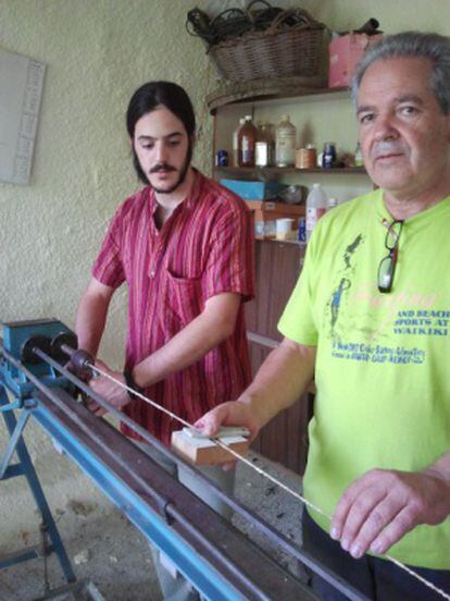 Joan Xandrich (izda.) y su hijo Albert, en su taller donde fabrican cuerdas para instrumentos.