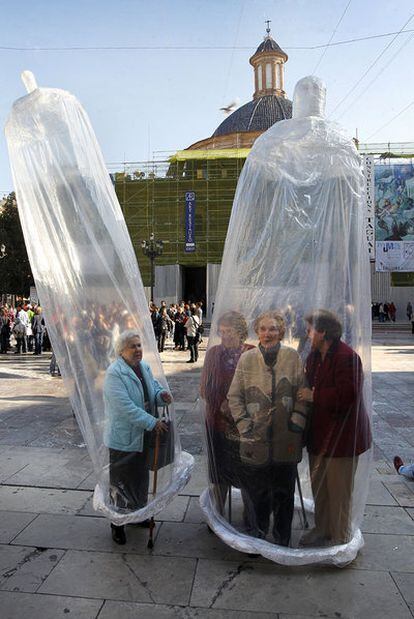 Mujeres enfundadas en dos preservativos gigantes celebran el Día Mundial del Sida, en la Plaza de la Virgen (Valencia).