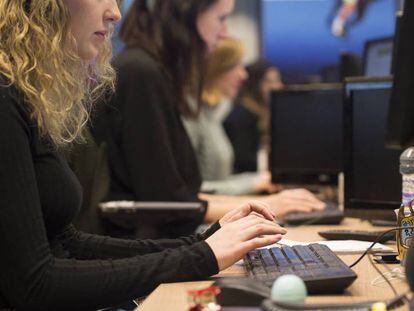 Empleados en sus puestos de trabajo en una oficina.