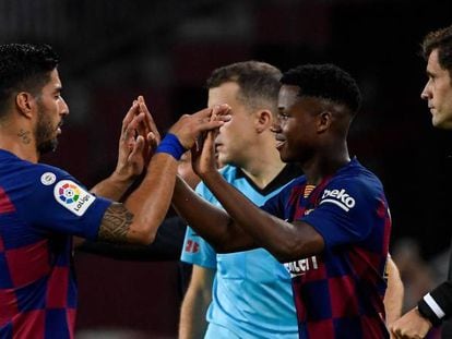 Fati choca las manos con Suárez en el cambio.