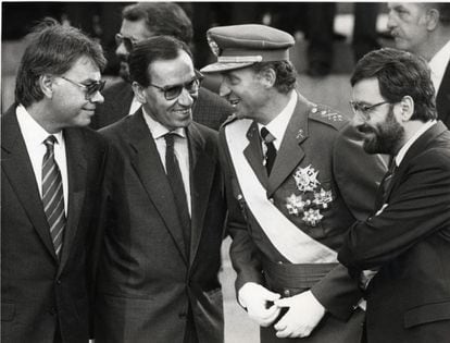 El Rey habla distendidamente con el presidente del Gobierno, Felipe González; el vicepresidente Alfonso Guerra y el ministro de Defensa Narcis Serra, durante el desfile de la Fiesta Nacional de 1988.