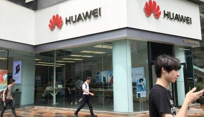 Varias personas pasan junto a una tienda de Huawei en Shenzhen, en China.