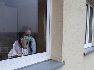 Una mujer mira a través de una ventana.
