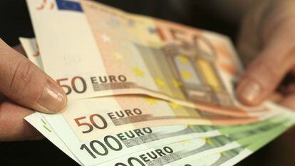 Una persona sostiene billetes de euro.