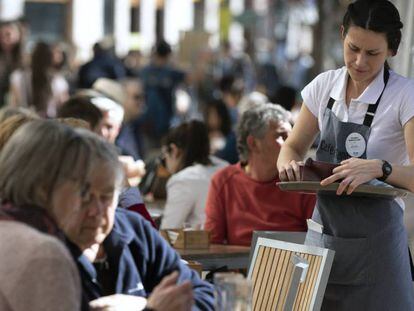 Una camarera en una terraza en la ciudad de Valencia. En vídeo, la ministra de Economía Nadia Calviño valora la EPA.