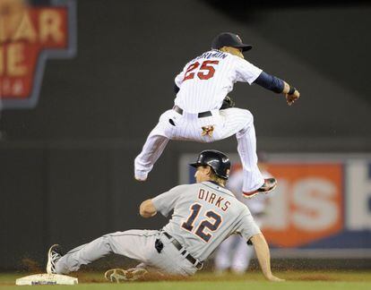 Andy Dirks, de Detroit Tigers, y Pedro Florimon, de Minnesota Twins, durante un partido de béisbol en Minnesota.