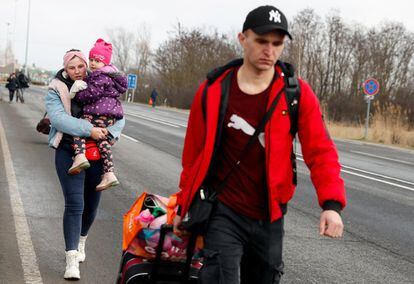 Una pareja abandona Ucrania caminando, a través de la frontera con Hungría. 