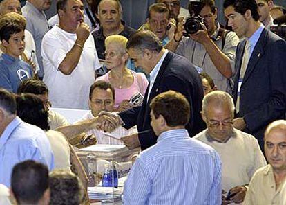 Lorenzo Sanz estrecha la mano del presidente de la mesa electoral en presencia de uno de sus hijos.