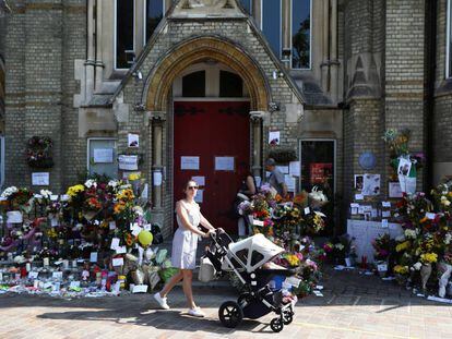 Una mujer con su beb&eacute; pasa este domingo junto a una zona de homenaje a las v&iacute;ctimas del incendio de la torre Grenfell, en North Kensington.