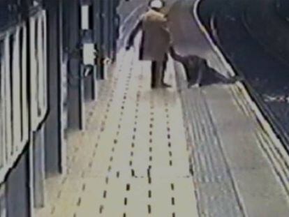 Un pasajero ayuda a otro a subir de las vías del tren en Reino Unido.
