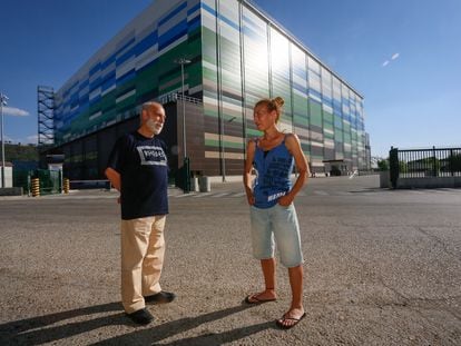 Francisco López, trabajador en una fábrica de Alcalá que cerró, y su hija Carmen, trabajadora en logística. Posan frente a una planta logística en la ciudad complutense.