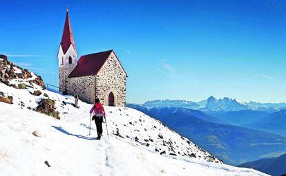 Una iglesia frente a la cadena montañosa de Los Dolomitas (Italia).