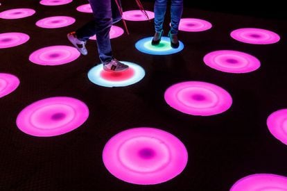 Dos personas recorren una instalación de arte con luces LED durante la presentación a los medios de la experiencia interactiva Pop-art 'Luces y Arte' en Kuala Lumpur, Malasia.