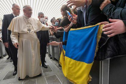 El papa Francisco saluda a unos fieles que sostienen la bandera de Ucrania, este martes en el Vaticano.