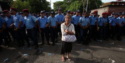 Una anciana protesta frente a un grupo de policías.