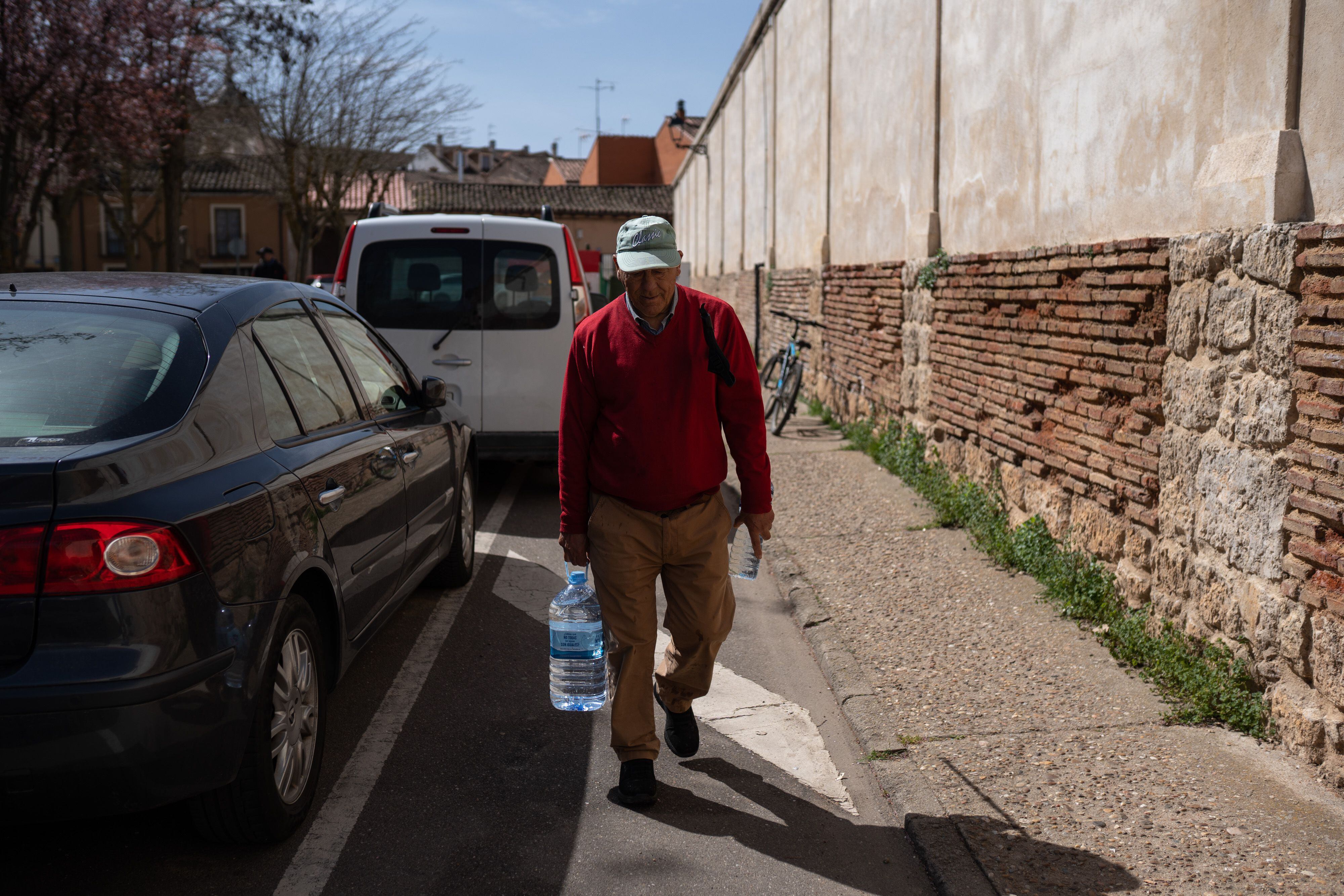 Francisco Brazuelo carga con una garrafa de agua mineral en una de las calles de Toro (Zamora). 