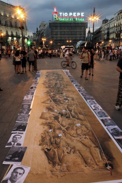 Fotografía a tamaño real de una fosa común con esqueletos de 29 fusilados colocada en la Puerta del Sol en 2010.