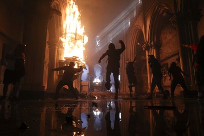 En el interior de la iglesia, los manifestantes protestaban y quemaban el mobiliario.