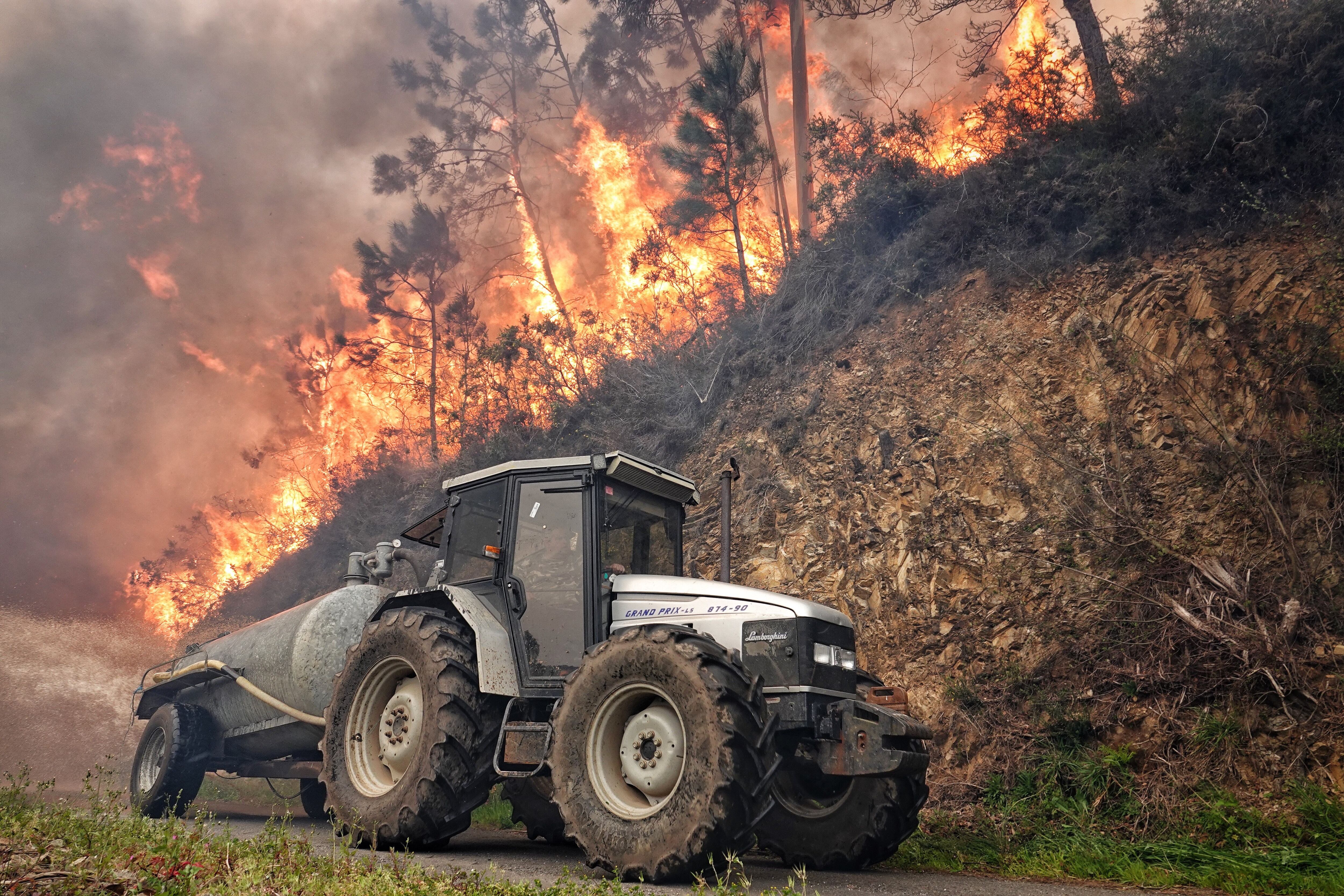Un tractor trabaja en la extinción del incendio de los concejos asturianos de Valdés y Tineo, el jueves.