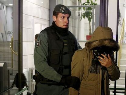 Un guardia civil conduce a un sospechoso fuera de las instalaciones del banco chino ICBC en Madrid.