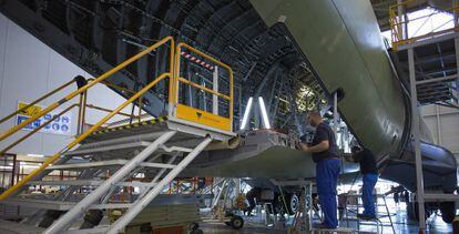 Los trabajadores prueban el portalón de carga tras haber pasado el avión por la fase de encendido eléctrico. La zona interior aún carece de revestimientos.