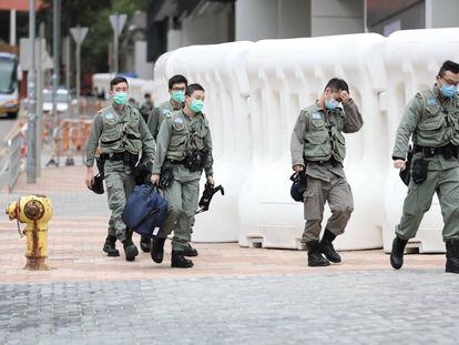 Agentes de seguridad protegidos con mascarillas en Hong Kong. 