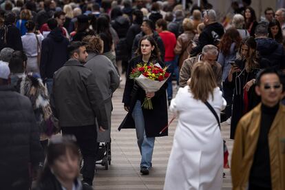 Una mujer pasea con un ramo de rosas por Barcelona, este martes en el día de Sant Jordi.